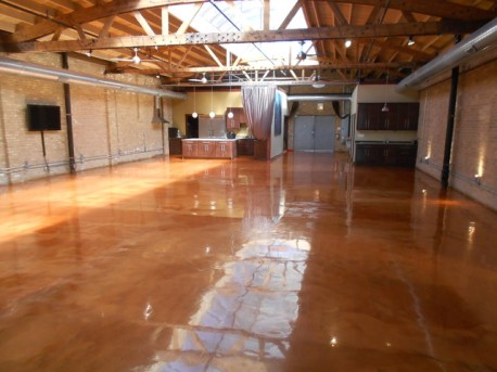 A wide space area function hall with a very shiny epoxy type of flooring on a brown color.