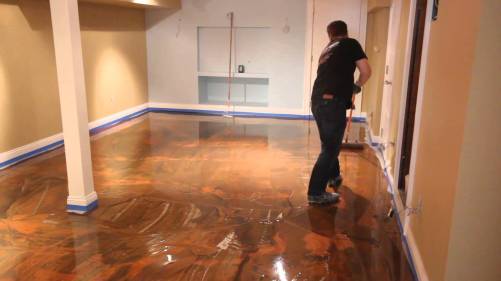 Man working the floor of the room to transform it into an epoxy flooring types with a good design